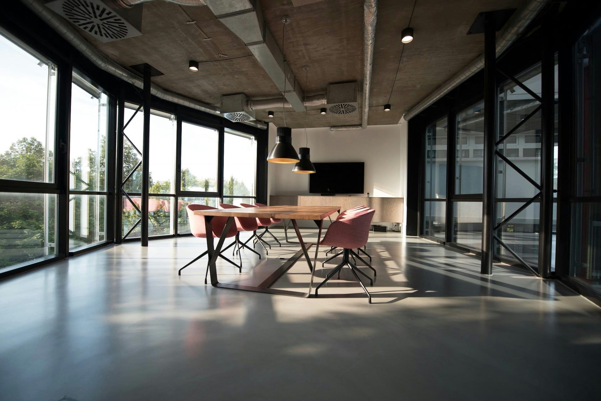 An open-plan office with clean desks, glass partitions and polished floors