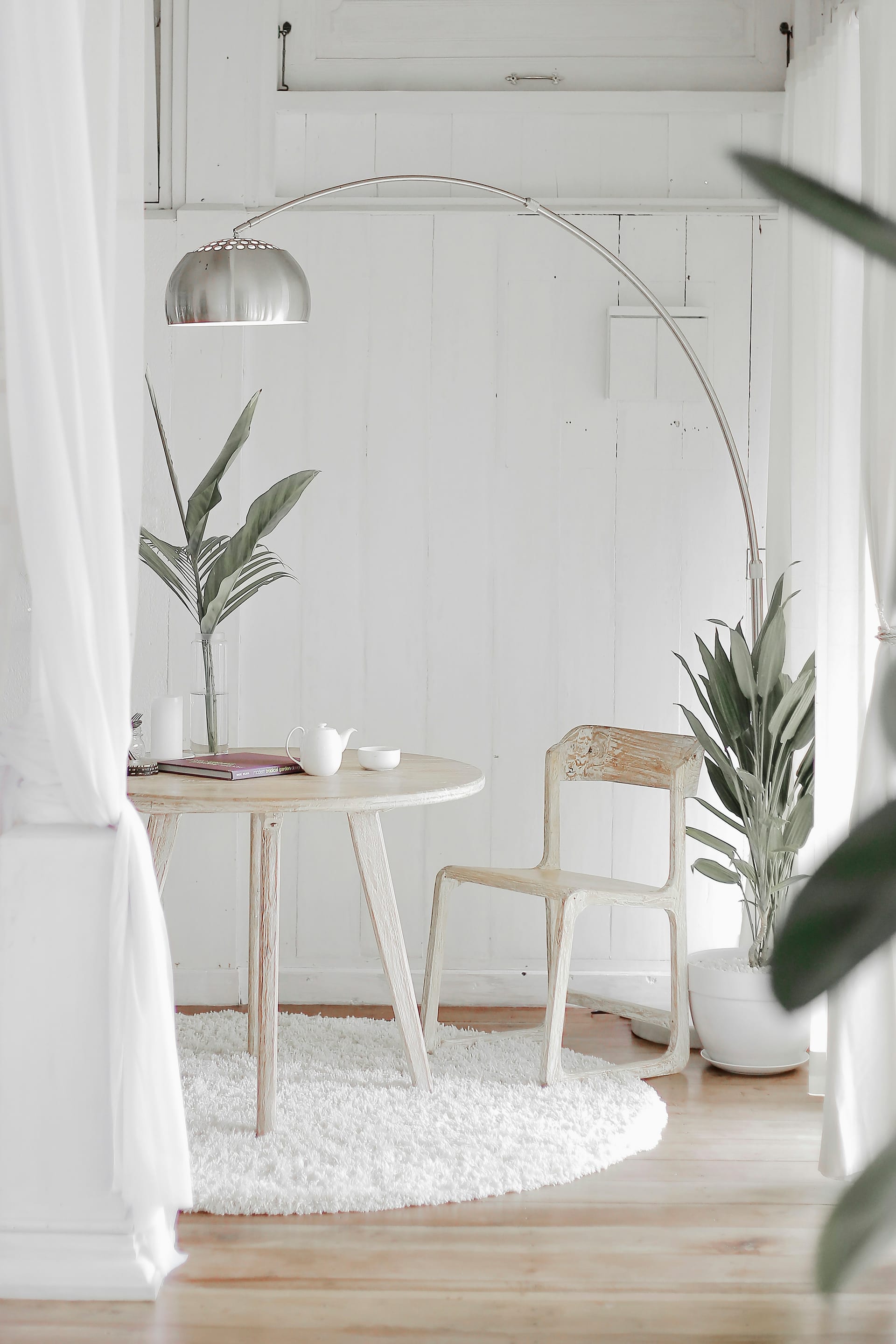 A calm, minimal room with a clean table and a single plant