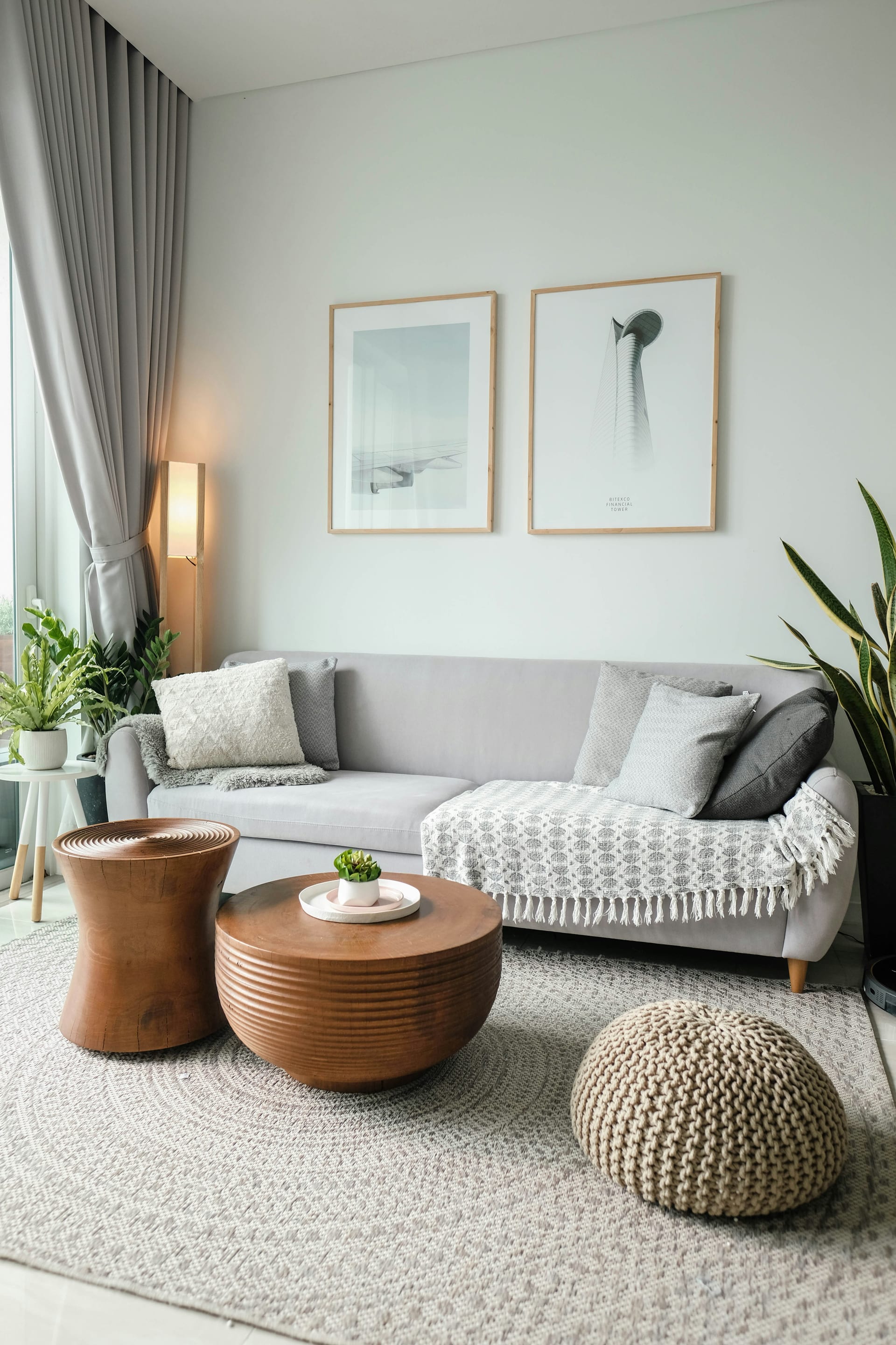 A tidy living room with a clean grey sofa and framed artwork