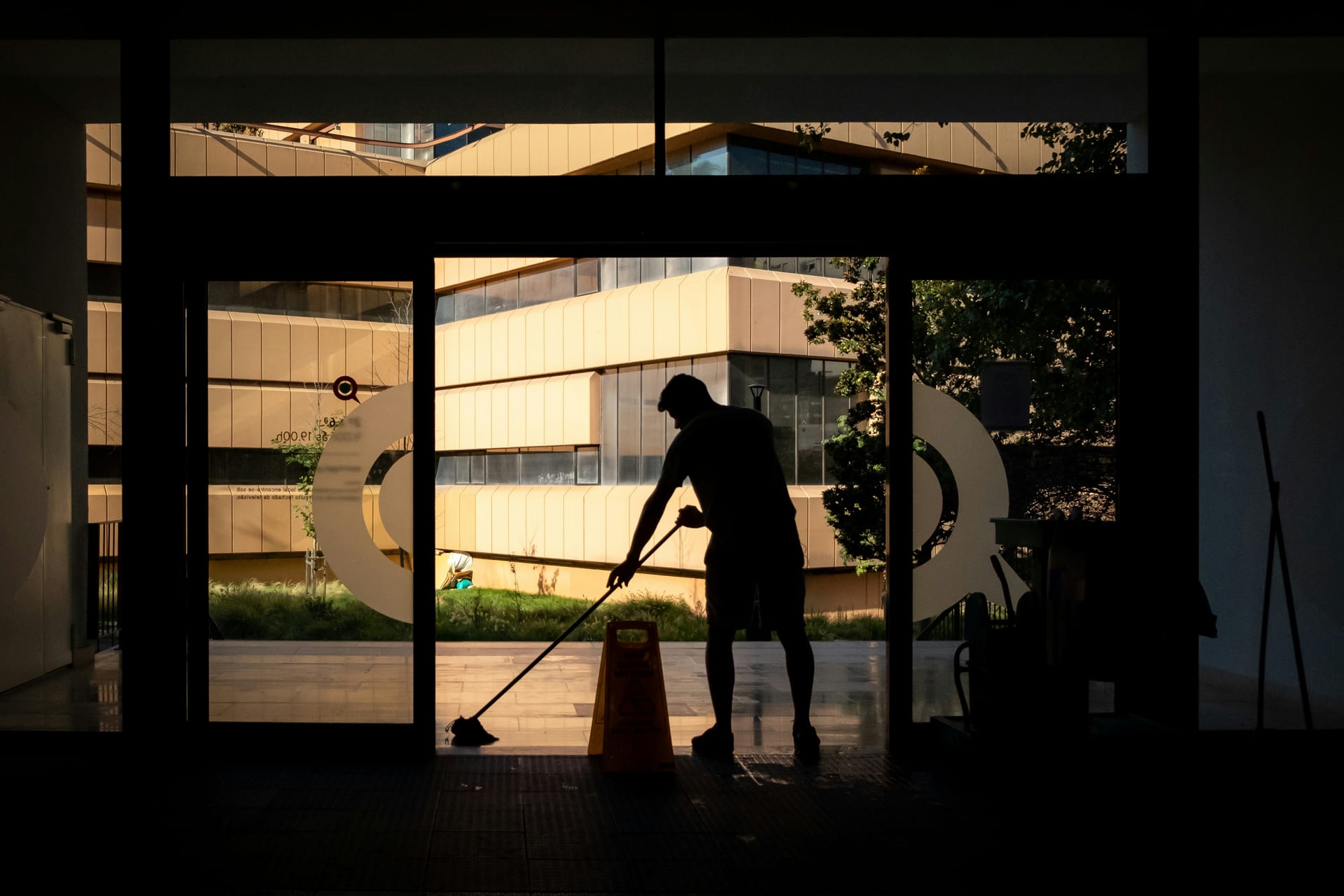 A cleaner mopping the floor of a commercial space after hours