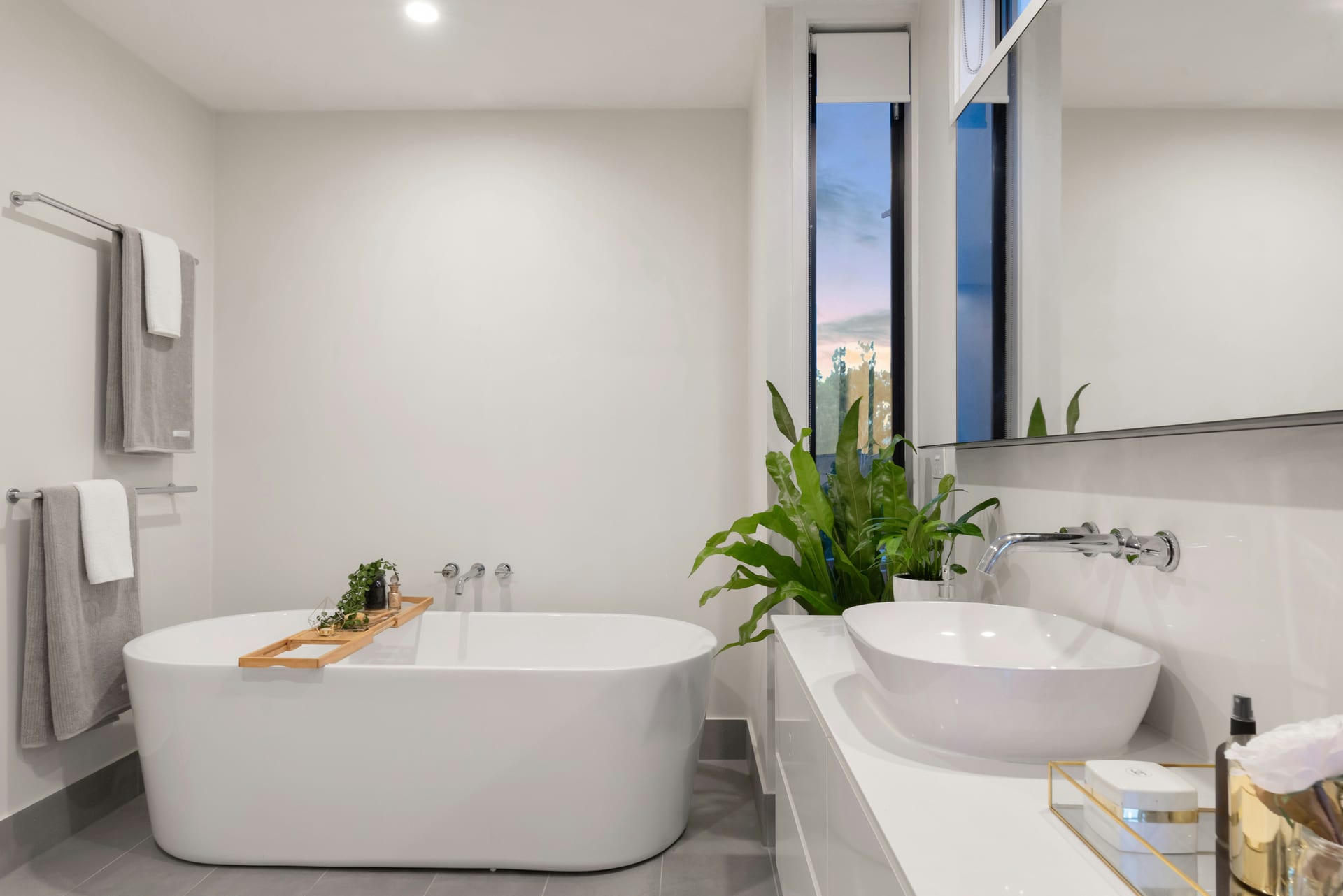 A bright white bathroom with a freestanding bath after a deep clean