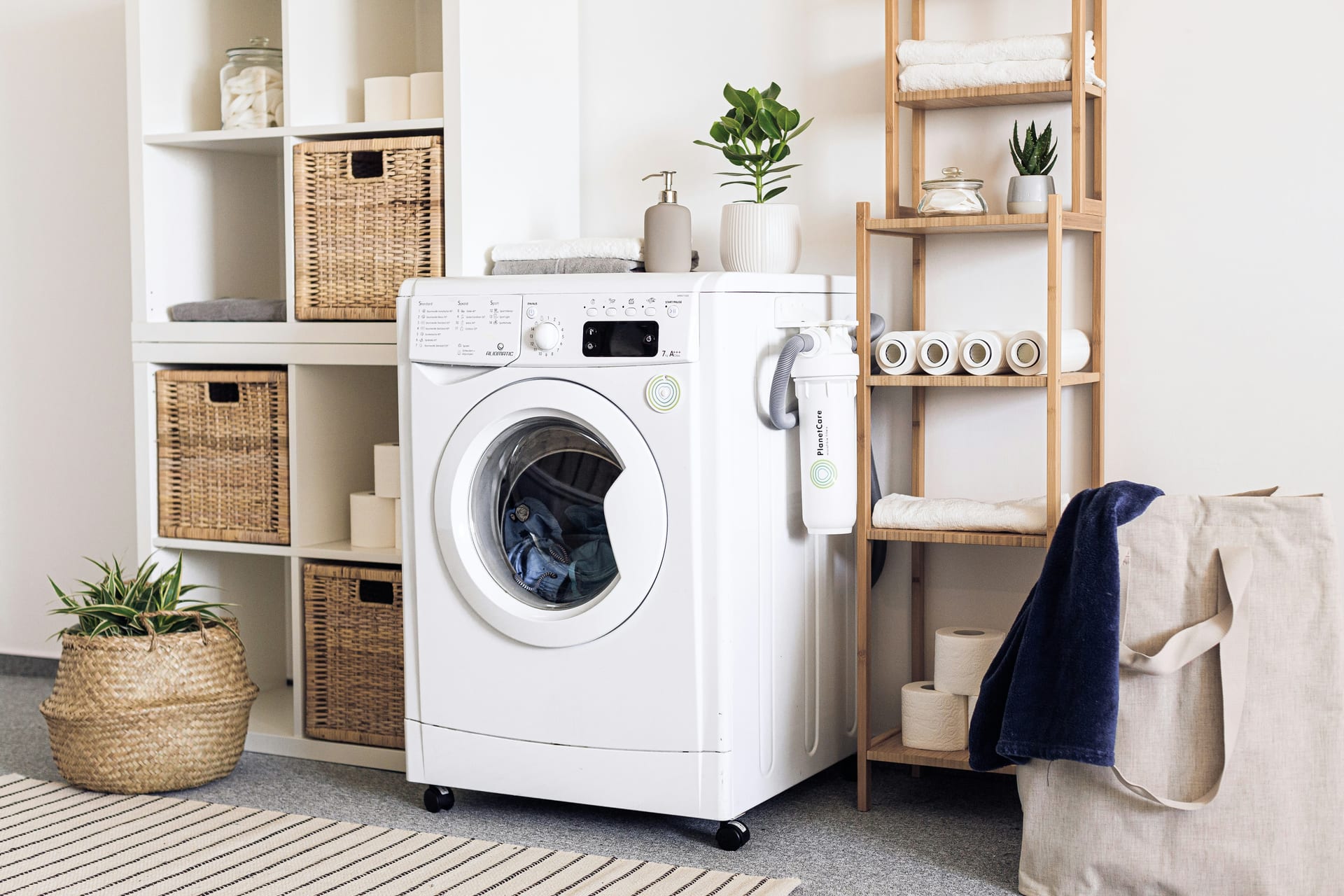A tidy utility room with a washing machine and neatly stored laundry baskets