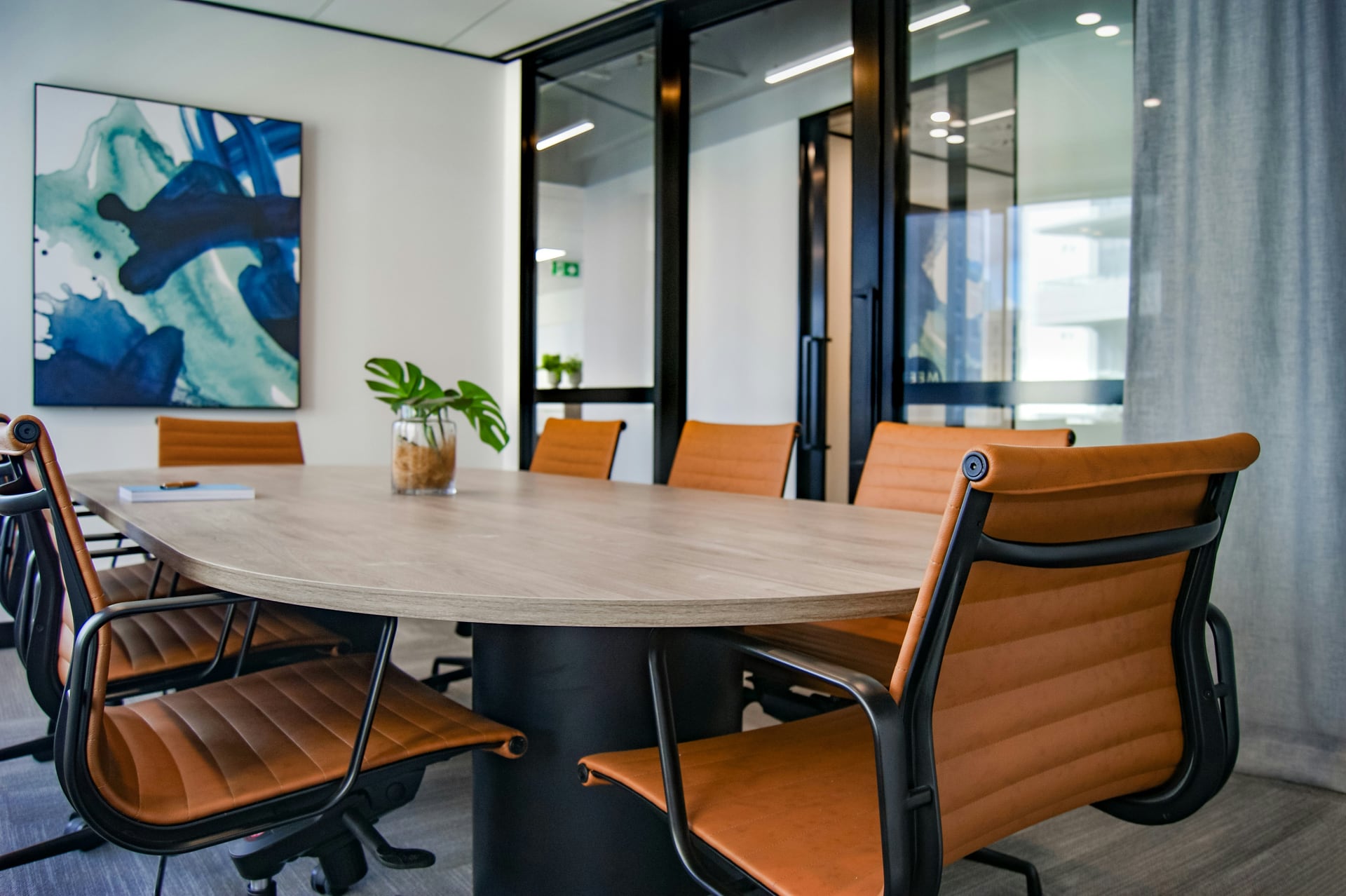 A clean office meeting room with a polished table and tidy chairs