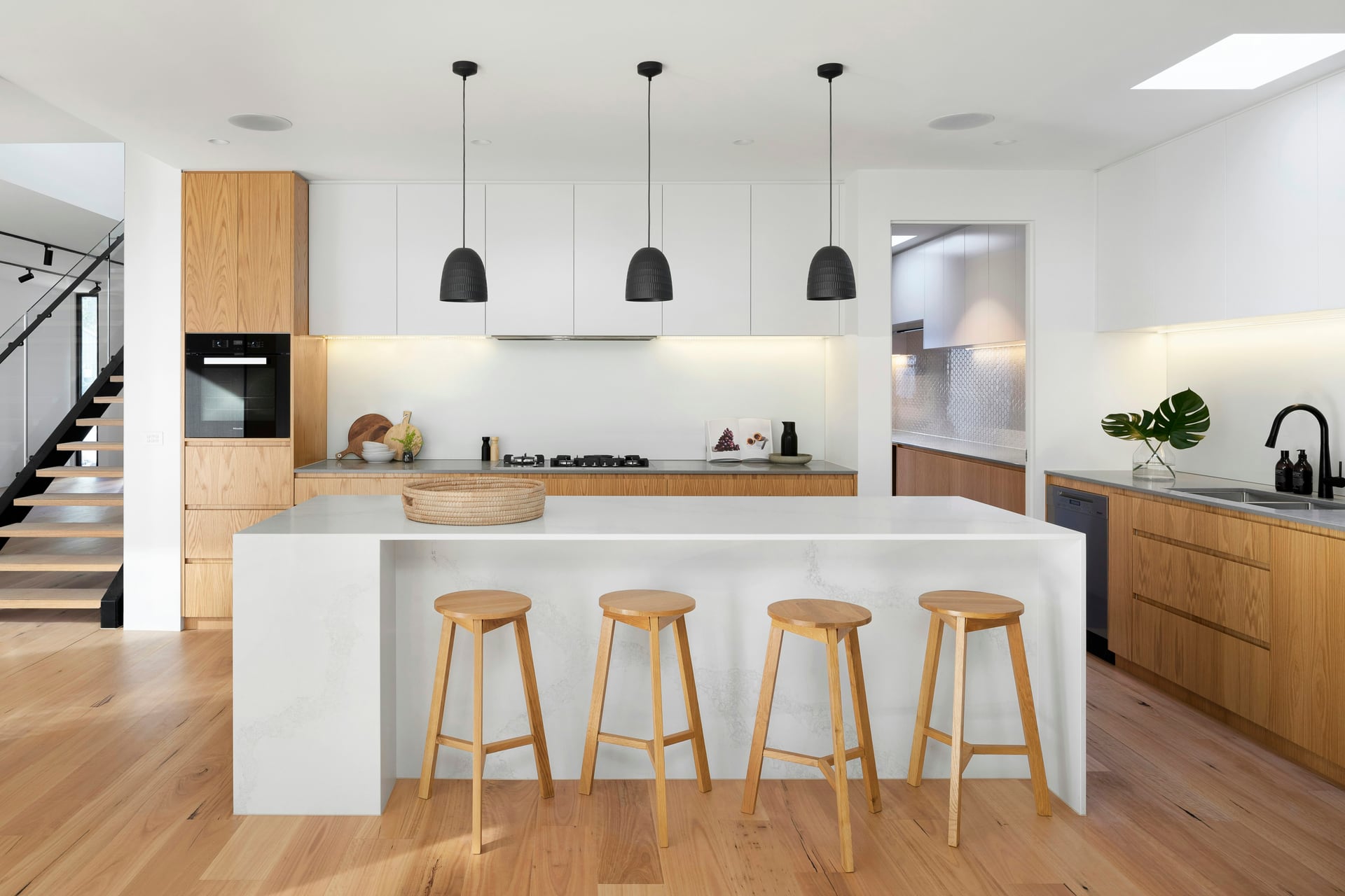 An immaculate kitchen island with polished worktops and pendant lighting overhead
